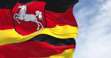 Açık bir günde Alman bayrağıyla dalgalanan Saksonya eyaleti bayrağı. Siyah, kırmızı ve sarı çizgili, ortasında armalar olan. Kusursuz 3 boyutlu animasyon. Yavaş çekim döngüsü. Seçici odaklanma. 4k