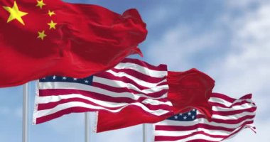 Açık bir günde Çin ve Amerika Birleşik Devletleri 'nin bayrakları rüzgarda sallanıyor. Uluslararası ilişki. Kusursuz 3 boyutlu animasyon. Yavaş çekim döngüsü. Seçici odak.