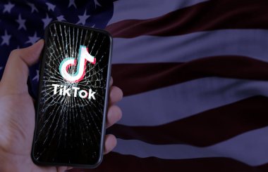 Washington, ABD, 18 Ocak 2024, Amerikan bayrağına karşı parçalanmış bir akıllı telefon ekranında TikTok logosu. Ulusal güvenlik kaygıları nedeniyle ABD 'de platform yasağı.