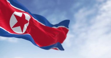 Açık bir günde Kuzey Kore bayrağının rüzgarda dalgalandığı yakın çekim. Yıldız ve mavi beyaz çizgili kırmızı bayrak. Kusursuz 3 boyutlu animasyon. Yavaş çekim döngüsü. Seçici odak, Dalgalanan kumaş.