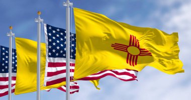 Close-up view of the New Mexico and United States flags waving in the wind on a clear day . 3d illustration render. Selective focus clipart