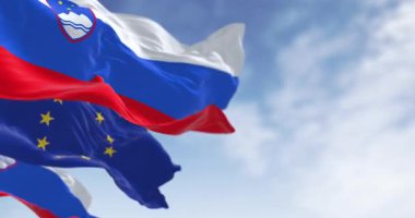 Slovenya ve Avrupa Birliği bayrakları açık bir günde birlikte dalgalanıyor. Kusursuz 3 boyutlu animasyon. Yavaş çekim döngüsü. Seçici odaklanma. Sinema 4k
