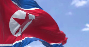 Açık bir günde Kuzey Kore bayrağının rüzgarda dalgalandığı yakın çekim. Yıldız ve mavi beyaz çizgili kırmızı bayrak. Kusursuz 3 boyutlu animasyon. Yavaş çekim döngüsü. Seçici odaklanma. Sinema 4k