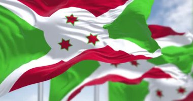 Burundi 'nin ulusal bayrakları açık havada sallanıyor. Kırmızı ve yeşil bölümlere bölünen beyaz köşegen, ortada üç yeşil yıldız. Yavaş çekim döngüsü. Kanat çırpan kumaş. Seçici odak