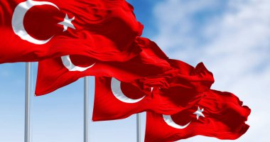 Hilal ve yıldızla açık gökyüzünün altında dalgalanan dört Türk bayrağı. Ulusal gurur, vatanseverlik, kimlik ve birlik kavramı