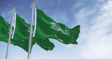 Üç Suudi Arabistan bayrağı açık bir gökyüzüne karşı rüzgarda sallanıyor. Birlik, kimlik ve egemenliğin güçlü bir ulusal sembolü. Kusursuz 3 boyutlu animasyon. Yavaş çekim döngüsü. Seçici odak