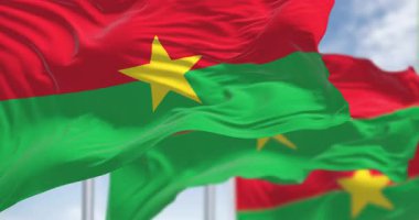 Rüzgarda dalgalanan çoklu Burkina Faso bayrakları canlı yeşil, kırmızı ve sarı bir yıldız. Birliğin, özgürlüğün ve ilerlemenin sembolü. Kusursuz 3 boyutlu animasyon. Yavaş çekim döngüsü. Seçici odak