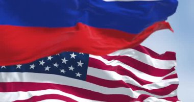 Rüzgarda dalgalanan Rus ve Amerikan bayrakları, parlak bir günde diplomasiyi, kimliği ve uluslararası ilişkileri simgeliyor. Kusursuz 3 boyutlu animasyon. Yavaş çekim döngüsü. Seçici odak