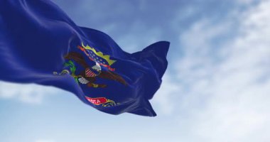 Kuzey Dakota eyaleti bayrağı açık havada rüzgarda sallanıyor. Mavi ve armalı. Kartal Kuzey Dakota parşömeninin üstünde. Kusursuz 3 boyutlu animasyon. Yavaş çekim döngüsü. Seçici odak