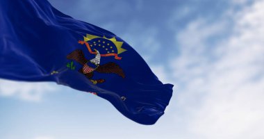 Kuzey Dakota eyaleti bayrağı açık havada rüzgarda sallanıyor. Mavi ve armalı. Kartal Kuzey Dakota parşömeninin üstünde. 3D illüstrasyon canlandırıcı. Seçici odaklanma. Dalgalanan tekstil