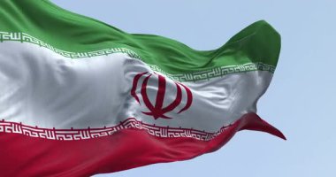 Detailed close-up of the Iranian flag, featuring the national emblem (Allah) and the Takbir written in Kufic script along the stripes. Seamless 3d render animation. Slow motion loop. Selective focus