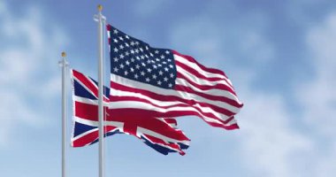 Birleşik Devletler ve Birleşik Krallık 'ın ulusal bayrakları rüzgarda dalgalanıyor. 3D canlandırma canlandırması. Ağır çekim. Seçici odak