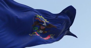 Kuzey Dakota eyaleti bayrağı açık havada rüzgarda sallanıyor. Mavi ve armalı. Kartal Kuzey Dakota parşömeninin üstünde. Kusursuz 3 boyutlu animasyon. Yavaş çekim döngüsü