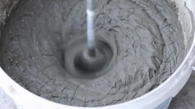 İnşaat mikseri macunu kovada karıştırıyor.