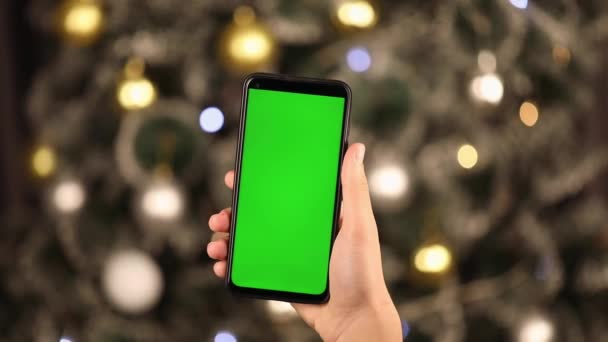 Руці Вертикально Телефон Зеленим Екраном Фоні Ялинки — стокове відео