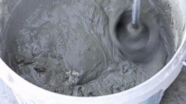 İnşaat mikseri macunu kovada karıştırıyor.