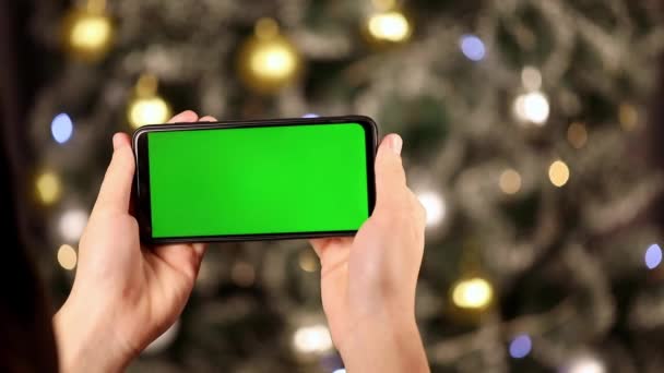 Руках Горизонтально Телефон Зеленим Екраном Фоні Ялинки — стокове відео