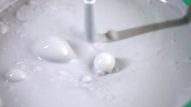 İnşaat mikseri beyaz boyayla baloncukları karıştırıyor