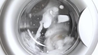 Çamaşır makinesinde açık renkli çamaşır yıkamak.