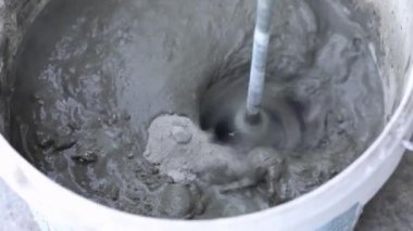 İnşaat mikseri macunu kovada karıştırıyor.