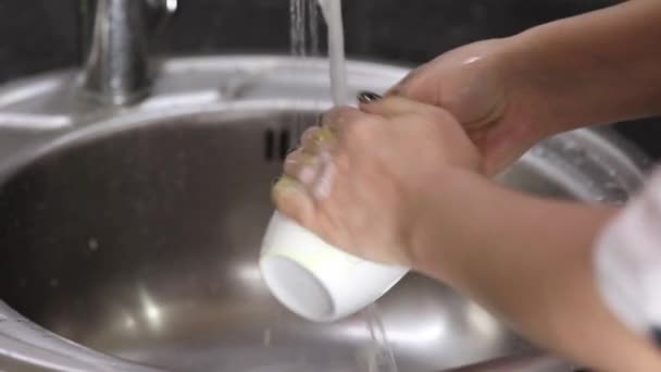 Perempuan Tangan Mencuci Cangkir Putih Dengan Busa Bawah Air Mengalir — Stok Video