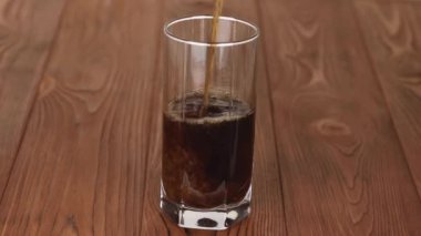 Köpüklü bir içecek, şeffaf bir bardağa dökülür.