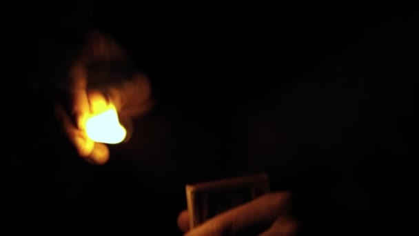手里拿着一个在黑暗背景下点火的打火机 — 图库视频影像