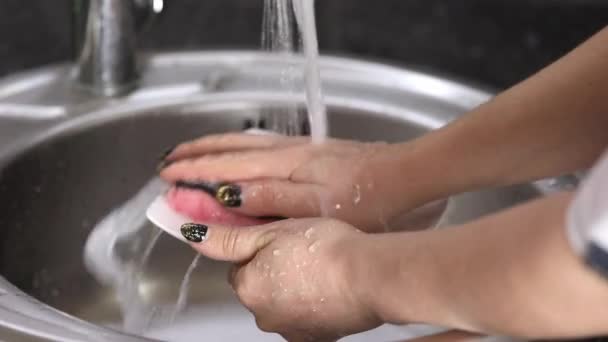 女用手在流动的水下面用泡沫洗白盘 — 图库视频影像
