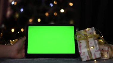 Noel arkaplanındaki bir bardak kahvenin yanında yeşil ekranlı tablet