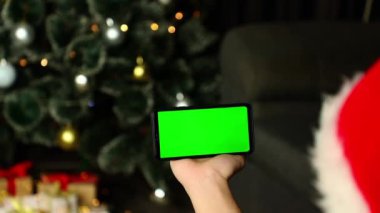 Noel arkaplanında yeşil ekranlı bir telefon.