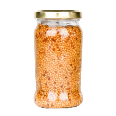 Beyaz arka planda izole edilmiş cam kavanozdaki hardal tohumları.