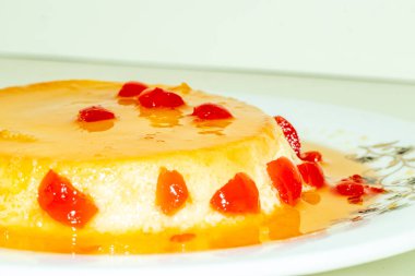 Sıfırdan vanilyalı puding yapmak, ev yapımı puding üzerine kırmızı kiraz meyvesi ile servis edilir. Puding, süt, şeker, un ve yumurta gibi malzemelerden yapılan pişirilmiş tatlı yemektir.