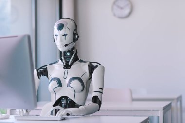 Android AI robotu masada oturuyor ve ofiste çalışıyor: yapay zeka, iş ve otomasyon konsepti
