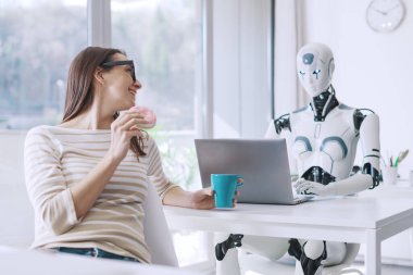 Tembel ofis çalışanı donut yiyor ve zamanını boşa harcıyor. Bilgisayarla çalışan becerikli yapay zeka robotuna bakıyor.
