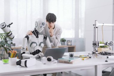 Bir çocuk bir robotun yardımıyla ders çalışır. Sonuç verimlidir. Robot ve İnsan İşbirliği Konsepti.