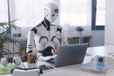 A humanoid robot works in an office on a laptop, showcasing the utility of automation in repetitive and tedious tasks. clipart