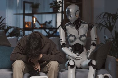 Üzgün çocuk video oyunu kaybediyor, bir android yapay zeka robotuyla oynuyor.