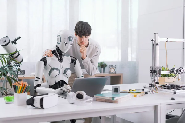 少年はロボットの助けを借りて研究しています その結果は実りある ロボットと人間のコラボレーションコンセプト — ストック写真