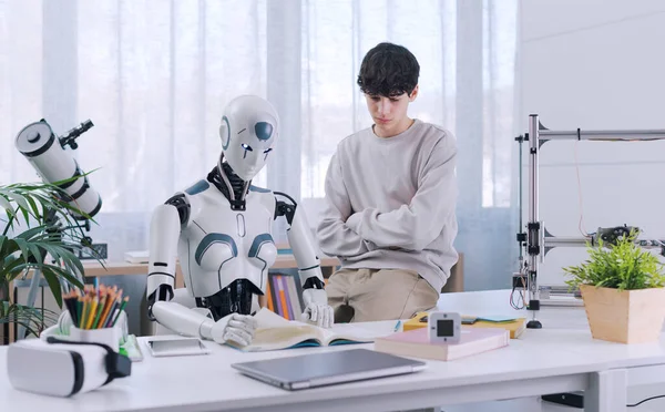少年はロボットの助けを借りて研究しています その結果は実りある ロボットと人間のコラボレーションコンセプト — ストック写真