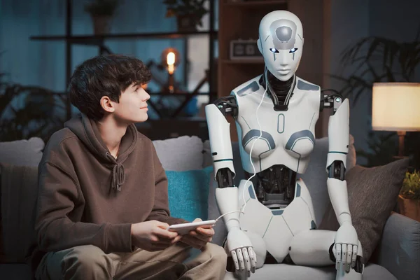 聪明的青少年在家里用数字平板电脑 科学和技术概念编程一个人形人工智能机器人 — 图库照片