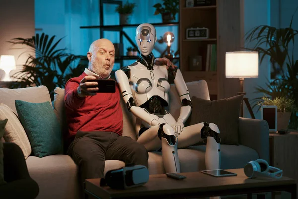 Sorrindo Homem Idoso Sentado Sofá Com Seu Robô Humanoide Tirando — Fotografia de Stock