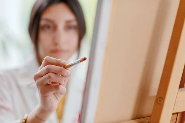 Young Confident Female Artist Painting Canvas Hand Holding Paintbrush Foreground — Stock Photo, Image