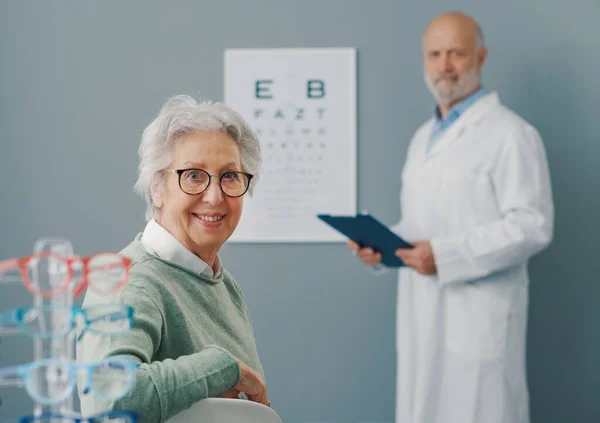 年长的女人和医生一起做眼科检查 她们对着相机笑 — 图库照片