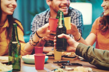 Mutlu arkadaşlar birlikte vakit geçiriyorlar, yemek yiyip kadeh kaldırıyorlar.