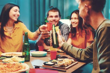 Mutlu arkadaşlar birlikte vakit geçiriyorlar, yemek yiyip kadeh kaldırıyorlar.