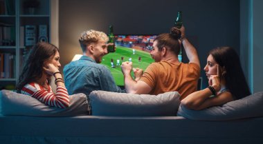 Sıkıcı kızlar, erkek arkadaşları TV 'de futbol izlerken birbirleriyle konuşup dedikodu yapıyorlar.