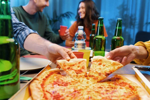Group of friends eating pizza together at home, fast food and food delivery concept