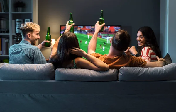 一緒にテレビでサッカーの試合を見ている若い友人のグループと彼らのチームのために応援 — ストック写真