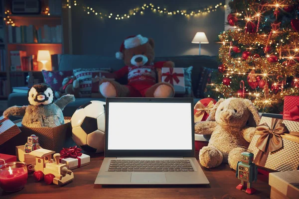 家庭内部有许多圣诞礼物和带有空白屏幕的笔记本电脑 — 图库照片