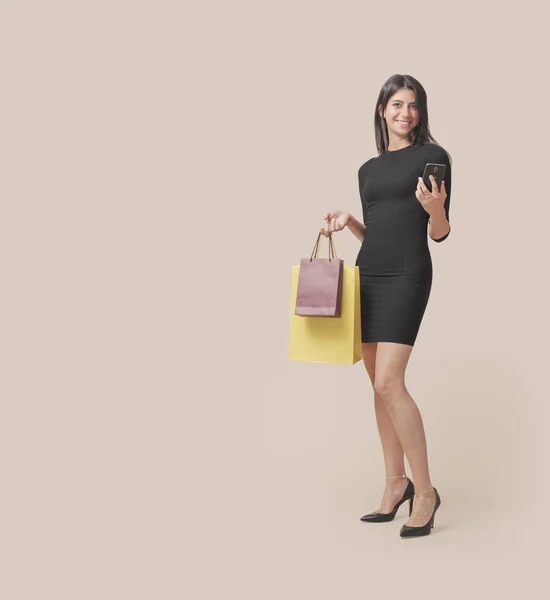 Ευτυχισμένη Μοντέρνα Γυναίκα Κρατώντας Τσάντες Για Ψώνια Και Ένα Smartphone — Φωτογραφία Αρχείου